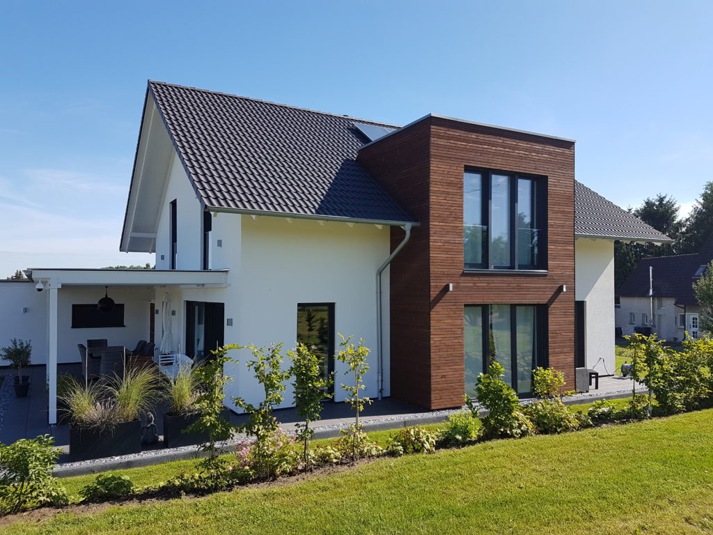 Ein moderner Klassiker mit klaren Linien - Dieses Einfamilienhaus mit Satteldach, weißer Putzfassade und schnörkelloser Architektur besitzt als Akzent einen Flachdach-Erker mit Lärchenholzverschalung.